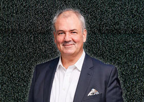 Picture of a man wearing a white shirt and dark jacket 